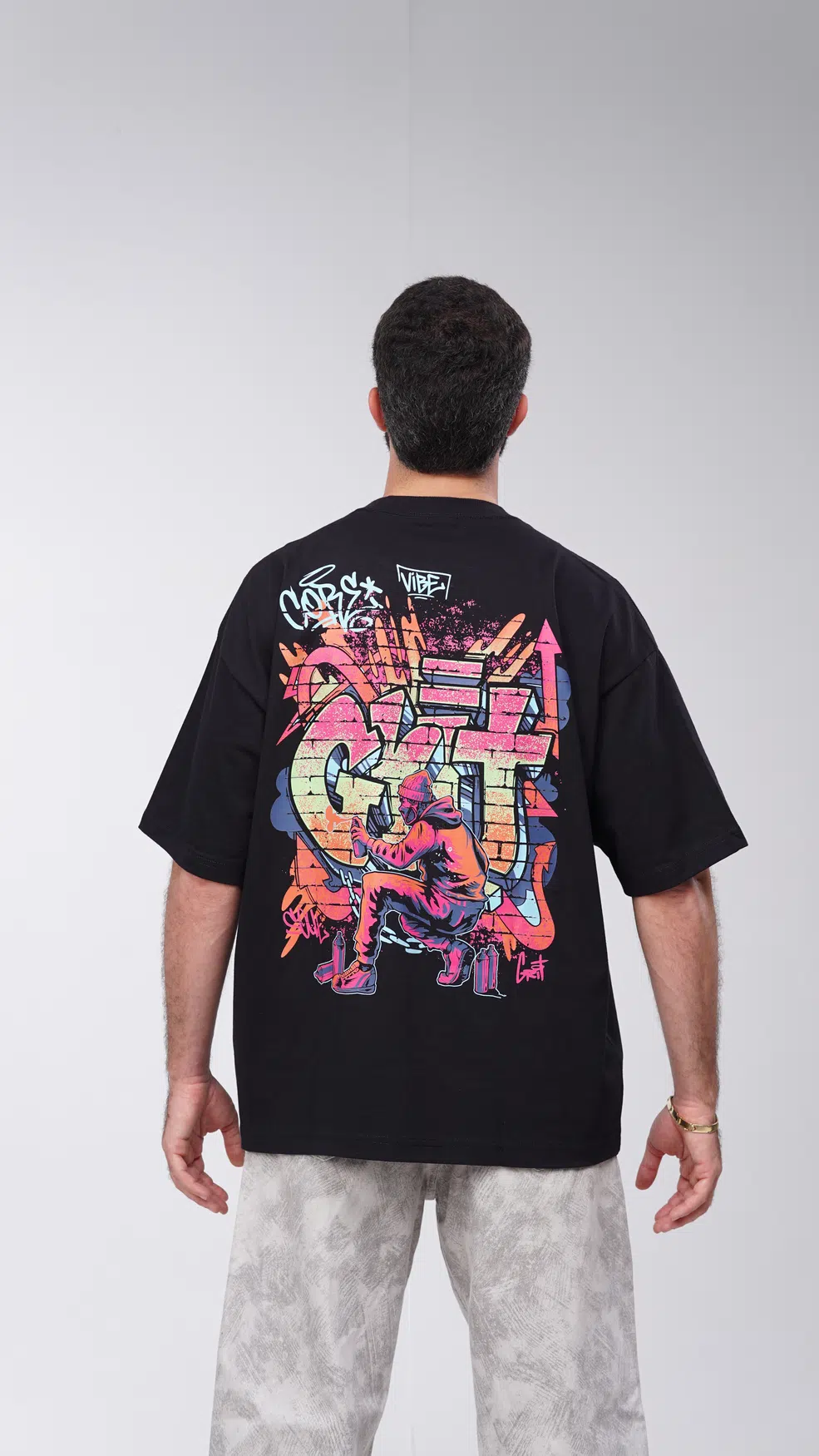 Modelo GRIT de costas com camiseta preta Graffiti Writer, estampa de grafite visível