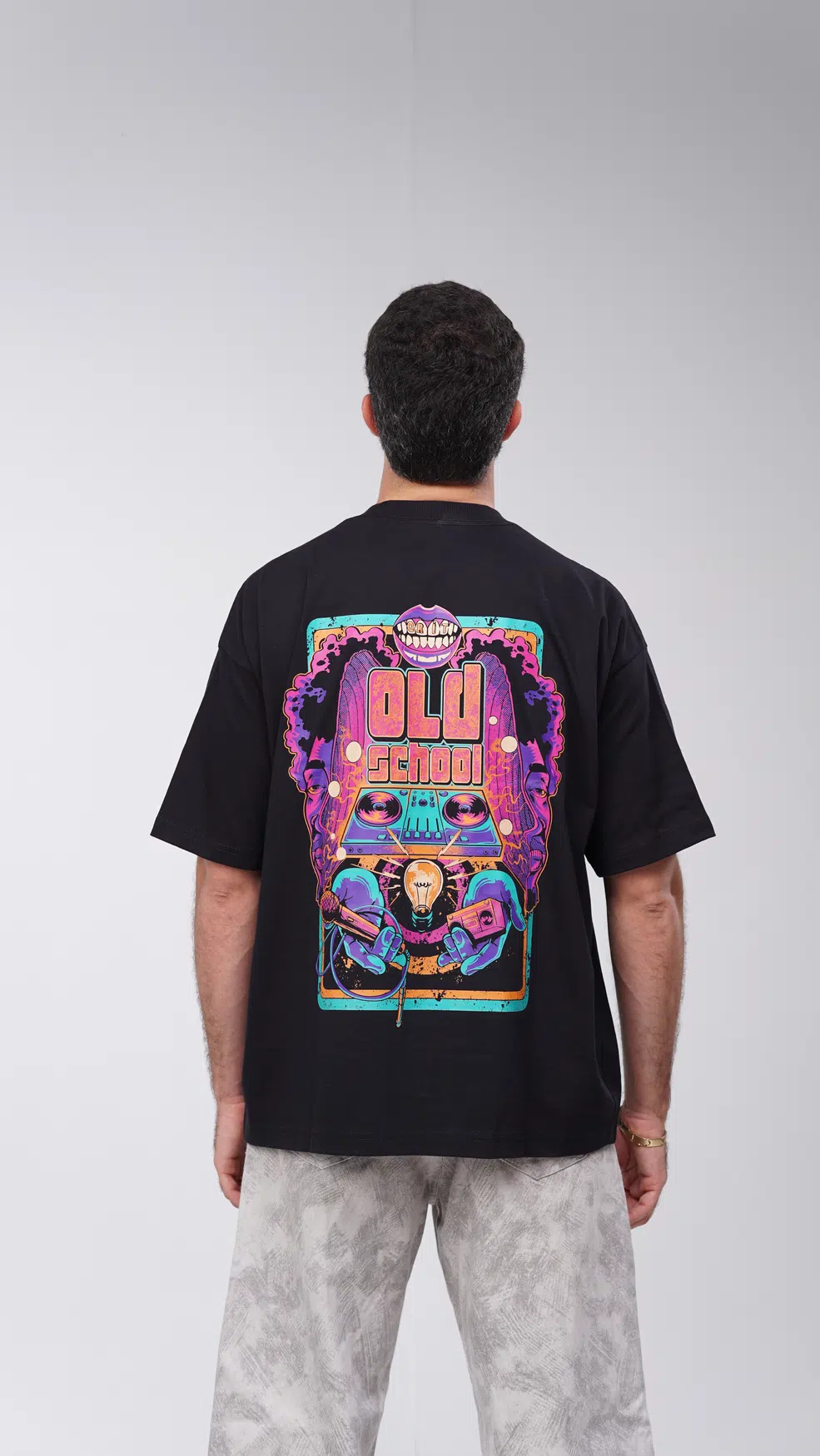 Modelo GRIT de costas com camiseta preta Old School, estampa de rap e hip-hop visível